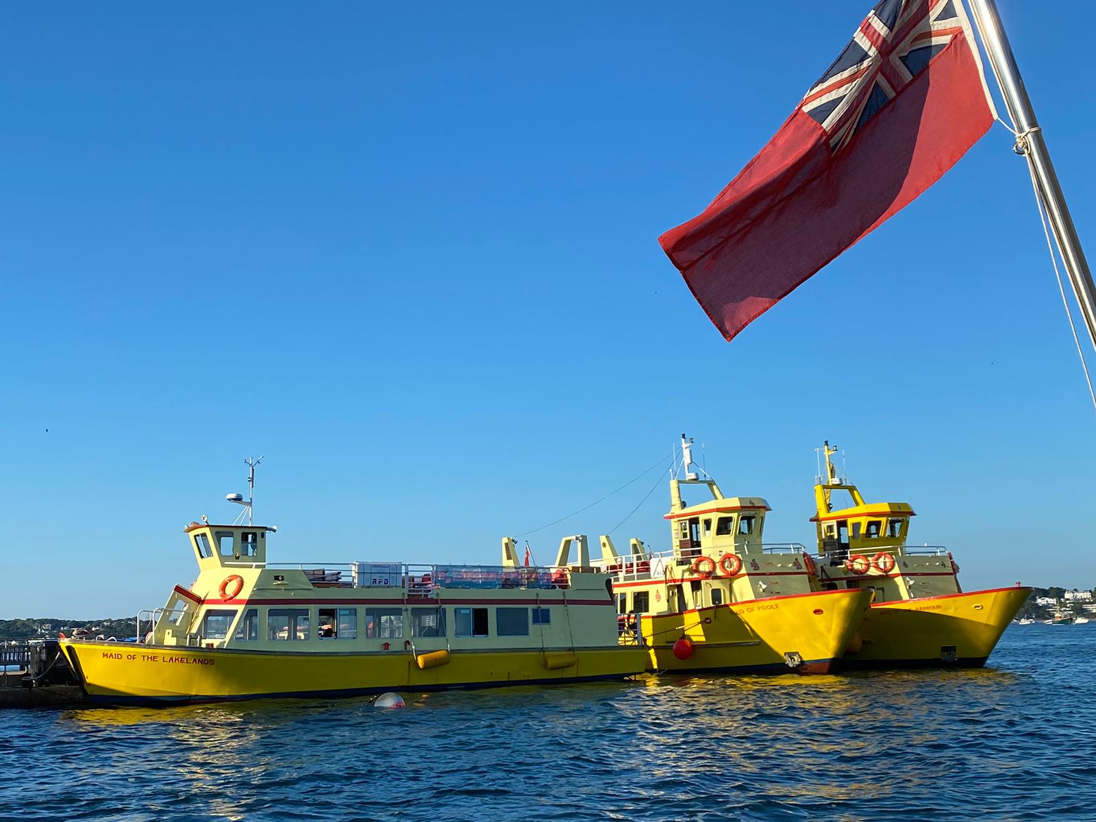Brownsea Boats fleet — Maid of the Lakelands, Maid of Poole and Maid of the Harbour moored at Poole Quay under a red ensign